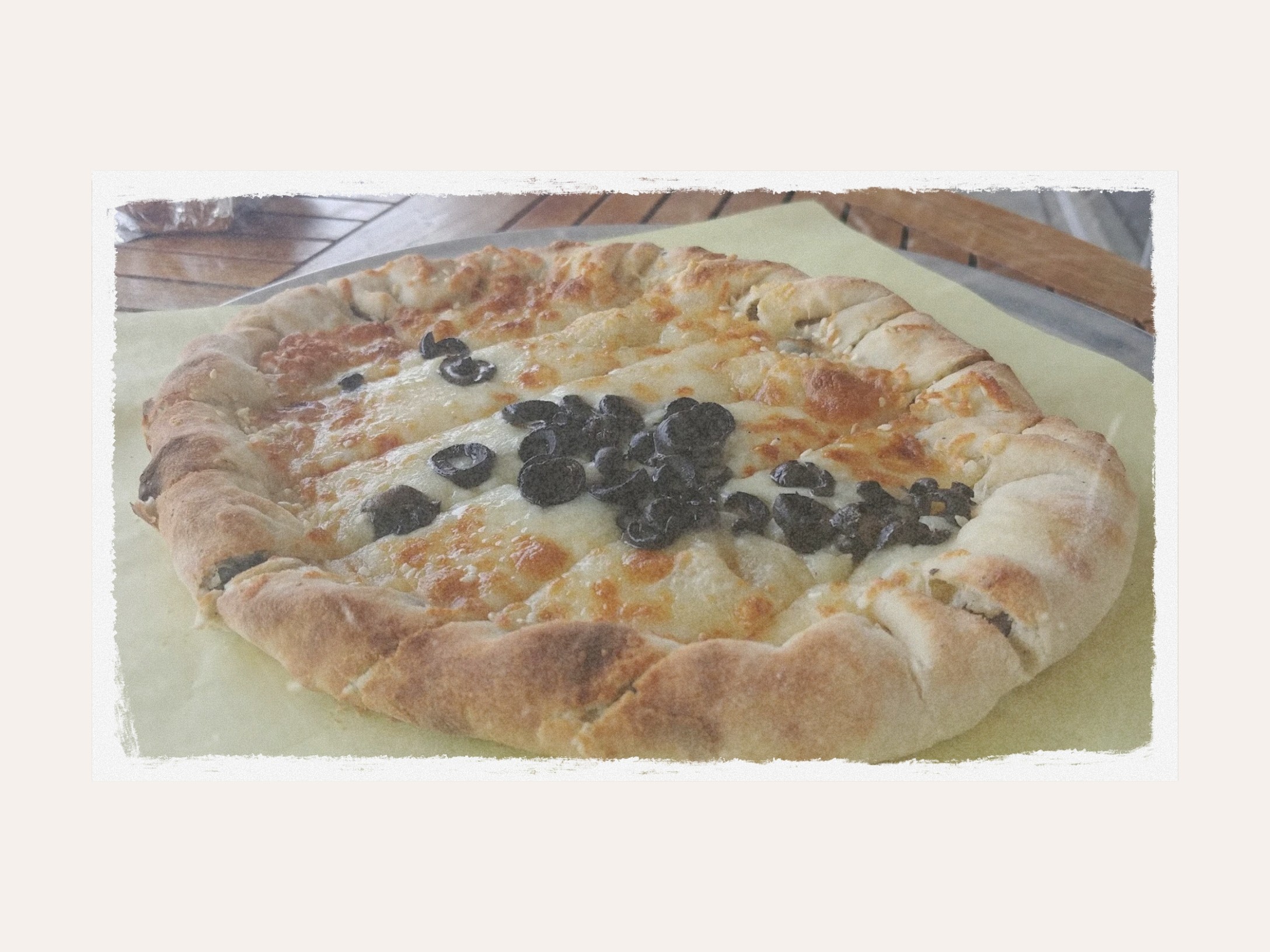 A cheese pie topped with black olives