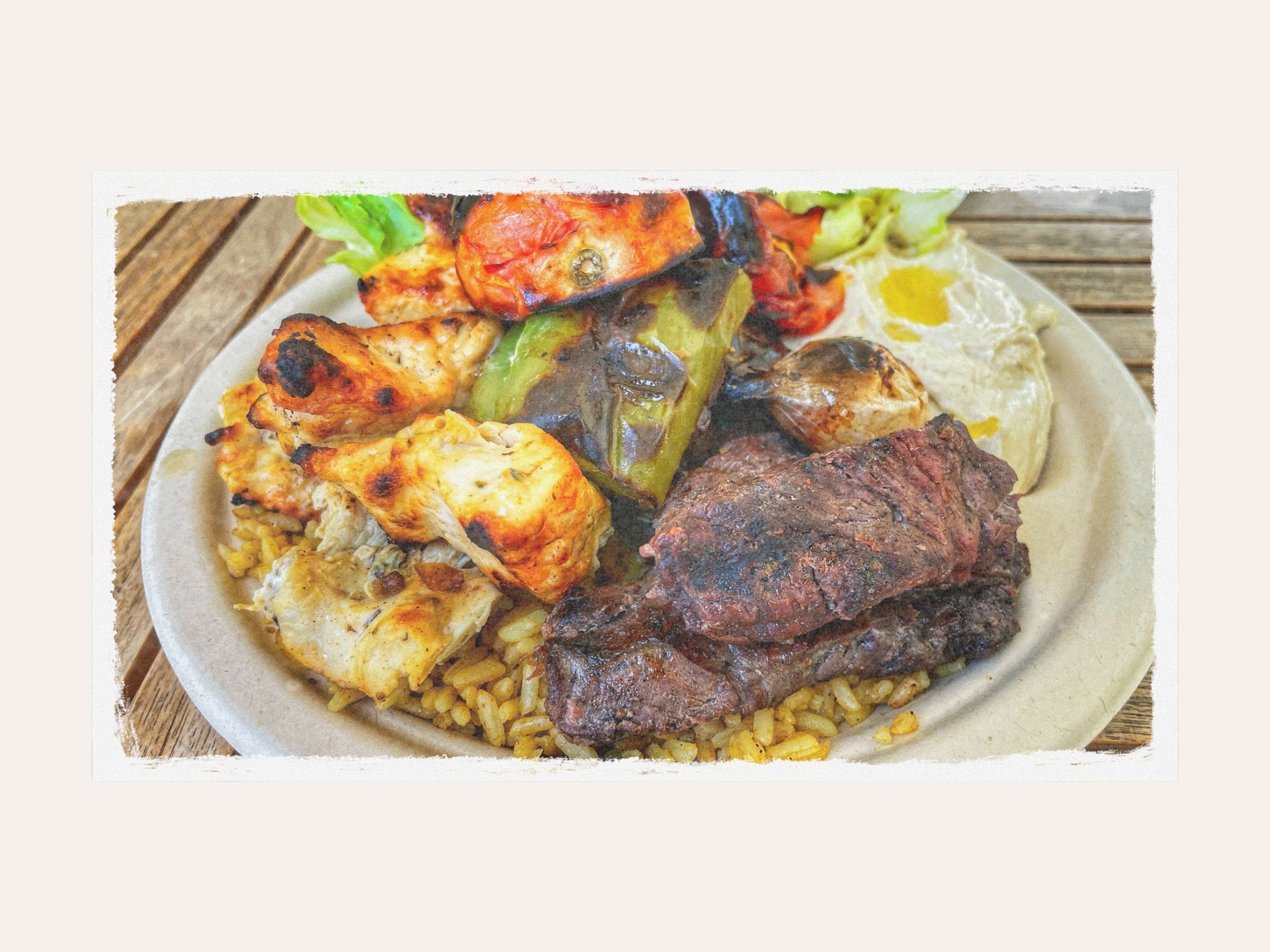A grilled chicken and beef kebab plate with rice and hummus