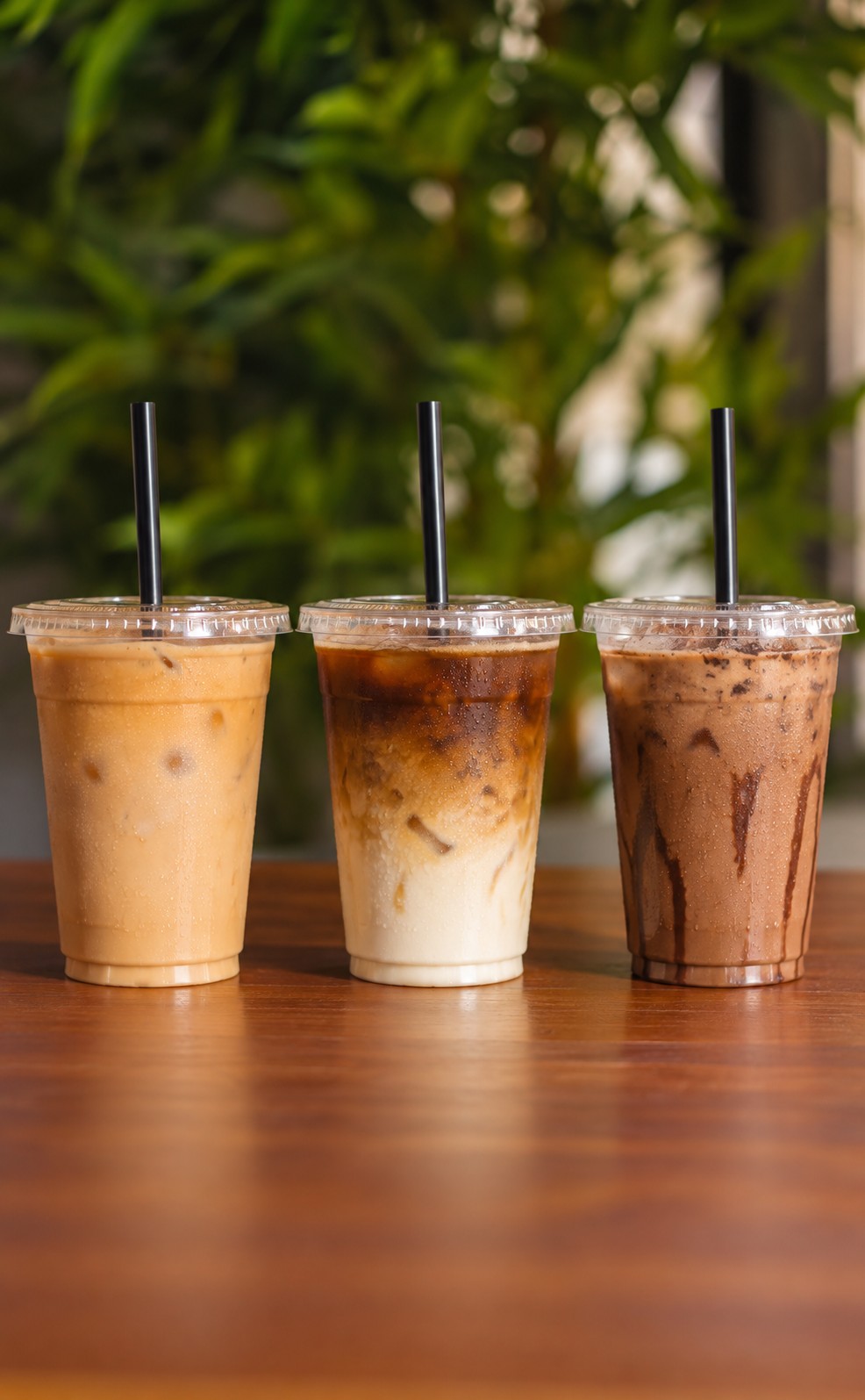 Three specialty coffee drinks in to-go cups