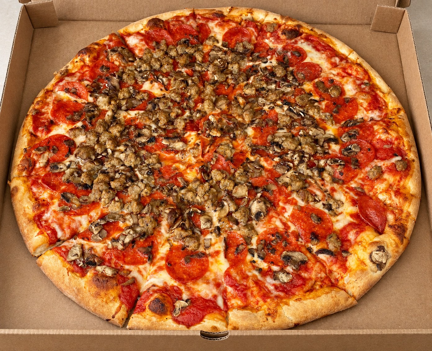 A sausage and pepperoni pizza fresh out of the oven