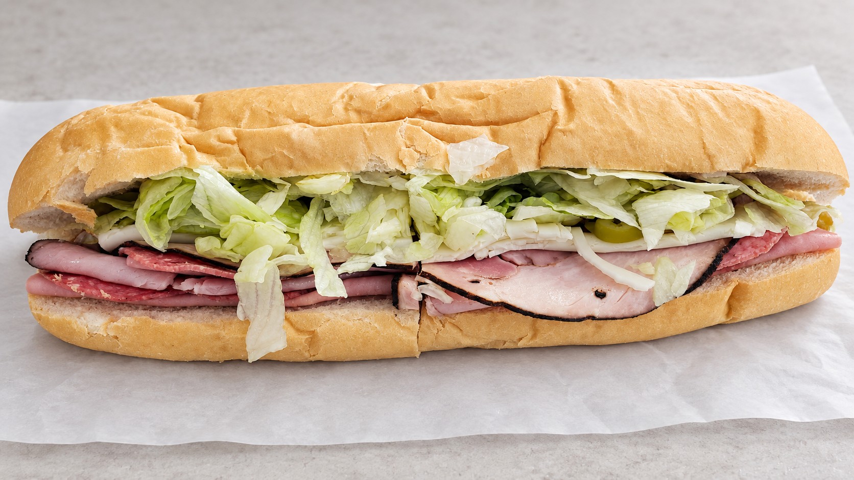 A cold-cut sub on a fresh roll with lettuce and tomato