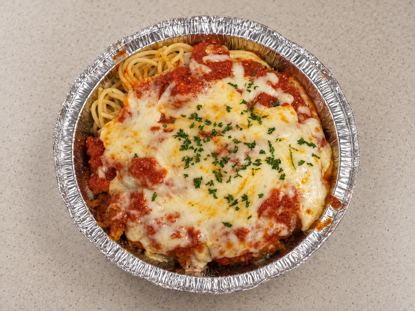 Spaghetti with marinara sauce in a foil tray